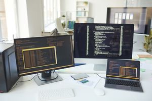 Code on developer monitors in a software-development office.