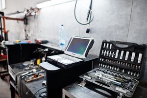 A laptop and tools at a garage maintenance service station.